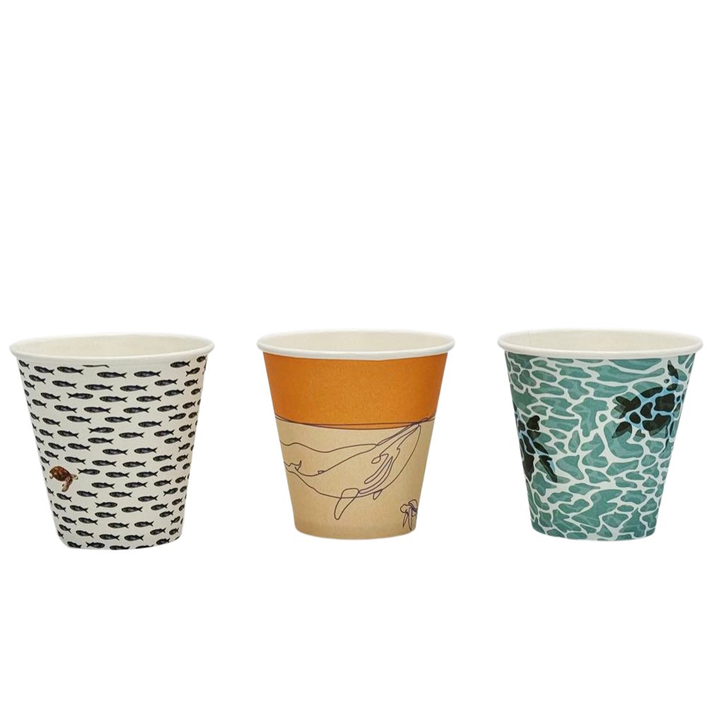 Three paper cups with different designs. The first has a black and white design, the second features a marine life design, and the third has a camouflage pattern.