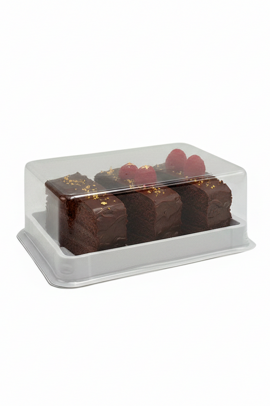 A clear plastic bakery display box with a white base containing three chocolate cake slices topped with red berries and gold flakes, photographed on a plain white background.