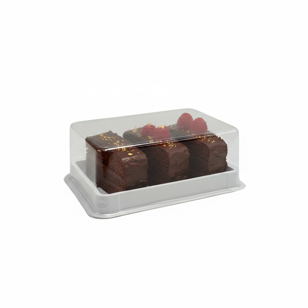 A clear plastic bakery display box with a white base containing three chocolate cake slices topped with red berries and gold flakes, photographed on a plain white background.